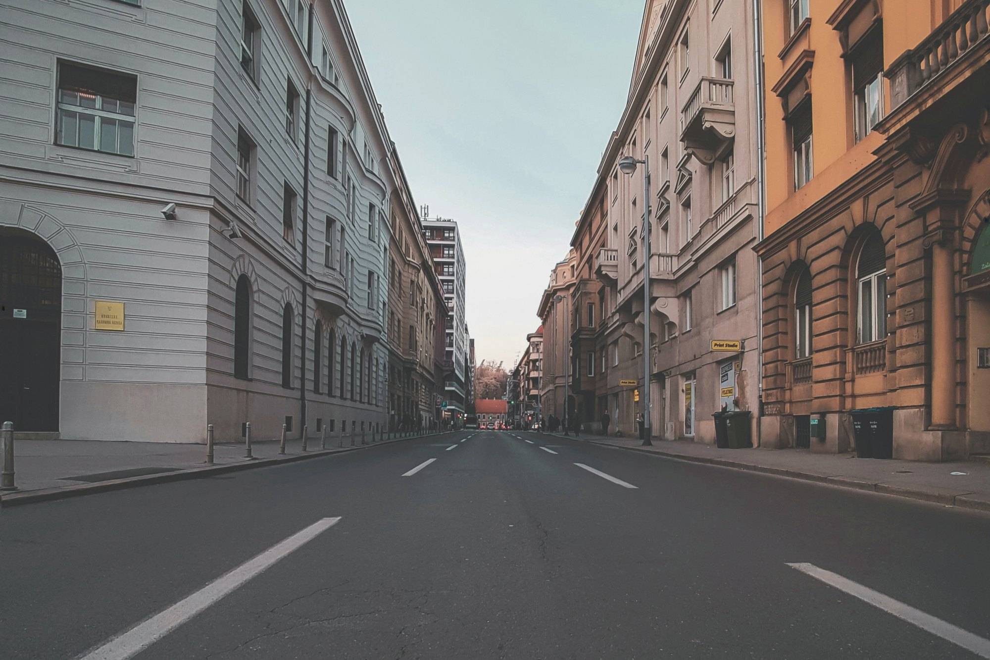 Leere Straße zwischen Altbauten einer europäischen Stadt in der Abenddämmerung